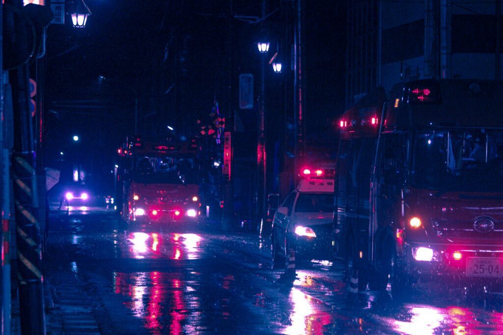 Emergency vehicles on a wet road at night 