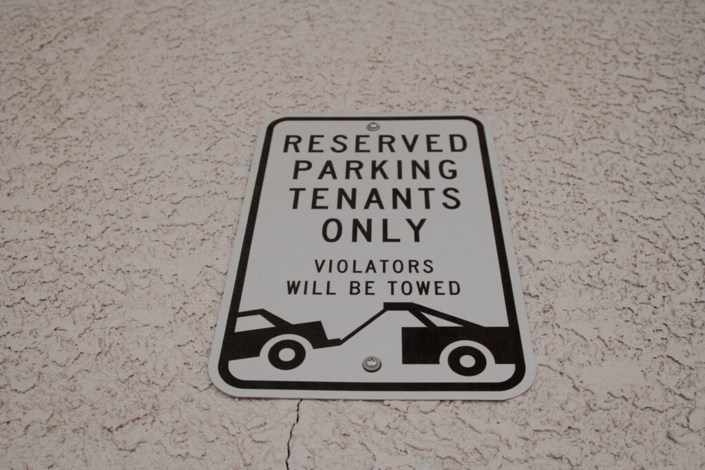 A sign reading “Reserved parking, Tenants only, Violators will be towed”