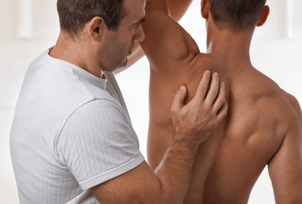 A physical therapist massages a patient's shoulder