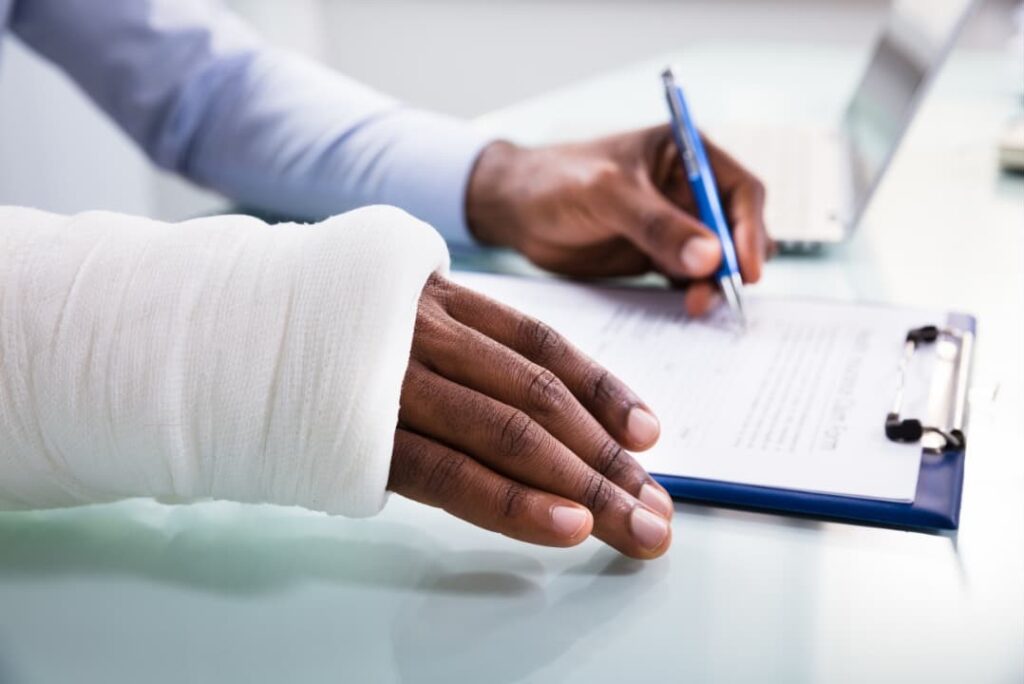 An injured man filing an insurance claim form