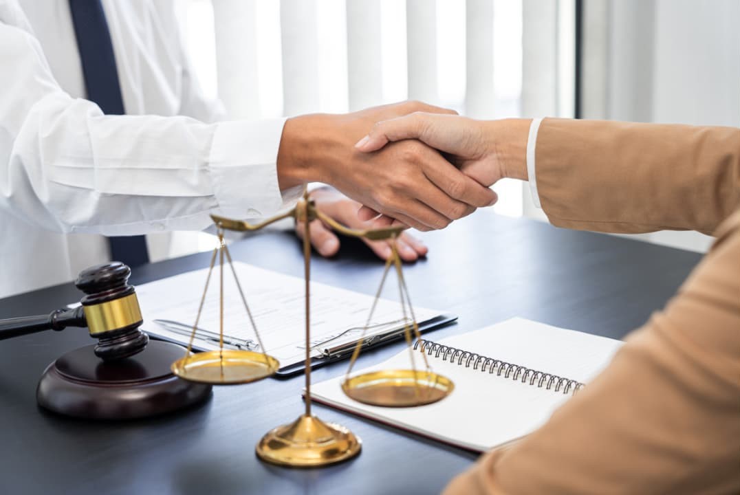 Two people shaking hands in an office during a personal injury case