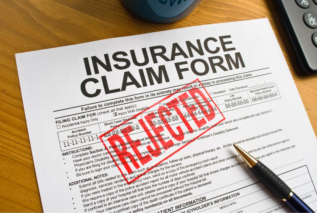 A denied insurance claim document on top of a table
