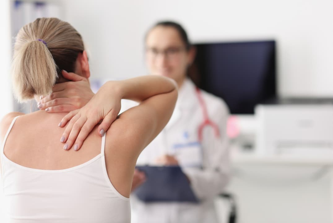 Patient with neck and back pain after a TBI consults with a doctor