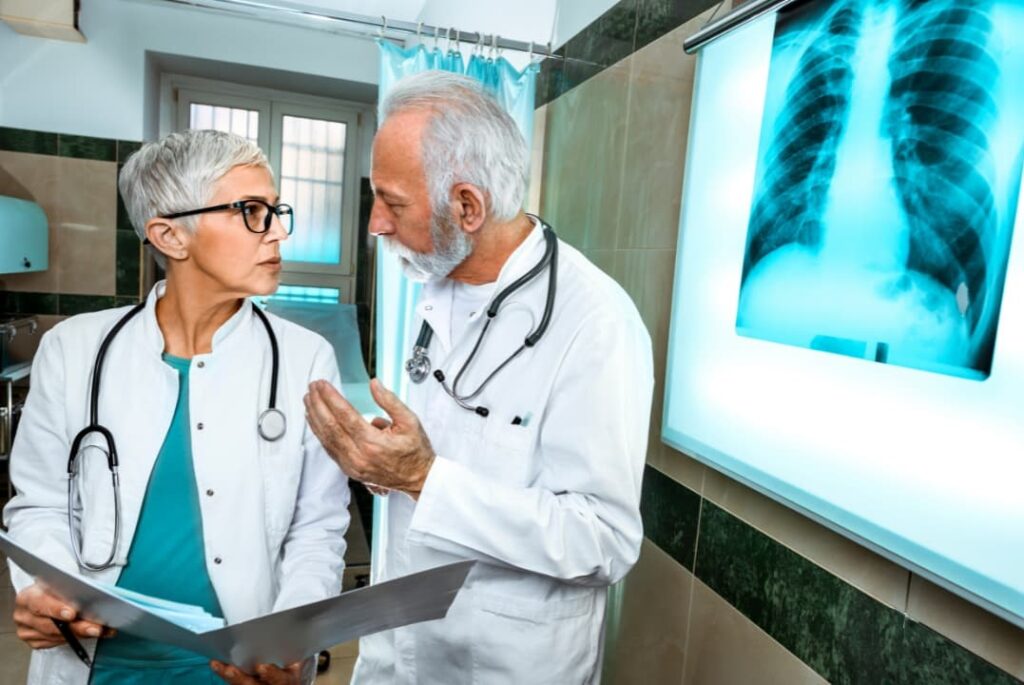 Two medical experts looking at a patient’s x-ray result determining the diagnosis