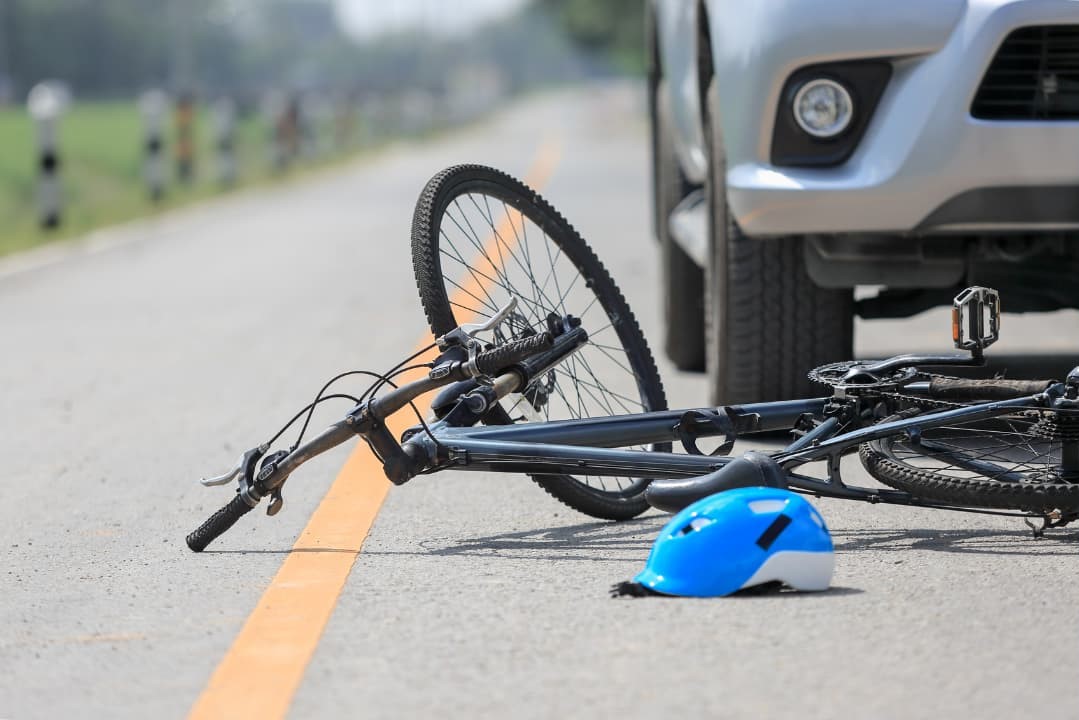 A bike laying on the ground from a bicycle accident