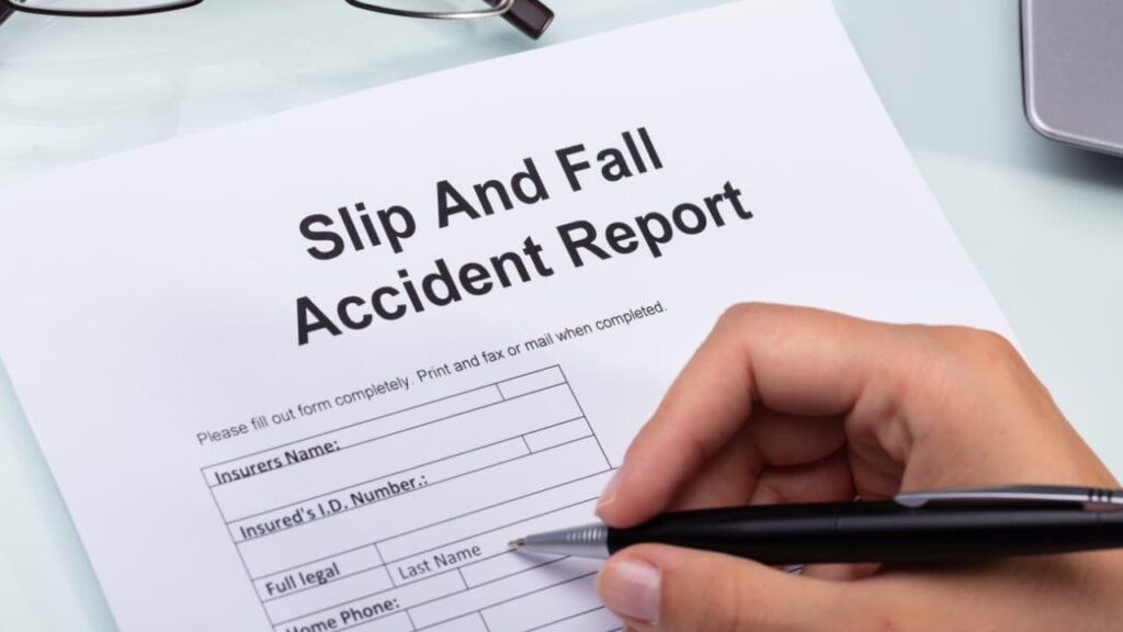 A person documenting a slip and fall accident with a written report.