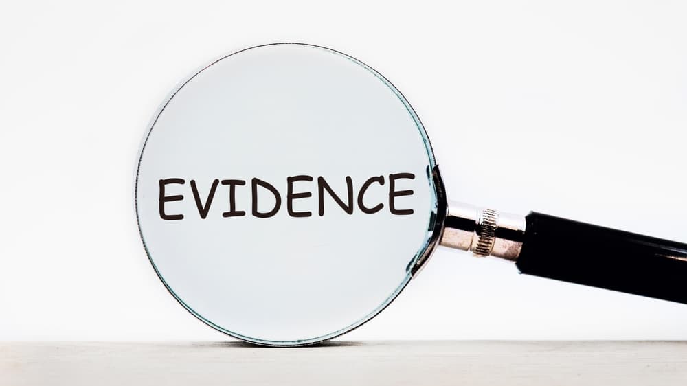 Looking through a magnifying glass at the word Evidence