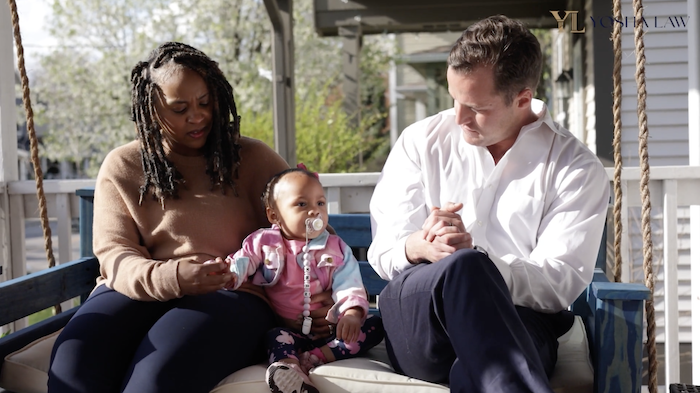 attorney brandon yosha with client and child